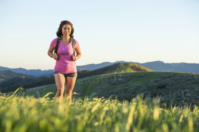 Asian woman hiking on hill