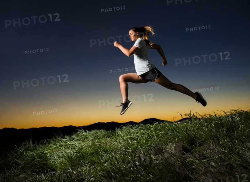 Caucasian woman running at sunset