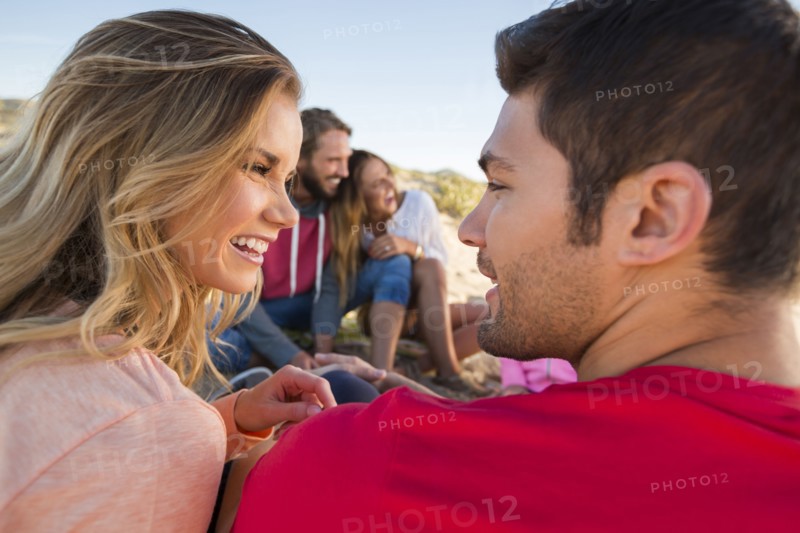 Smiling friends relaxing at beach