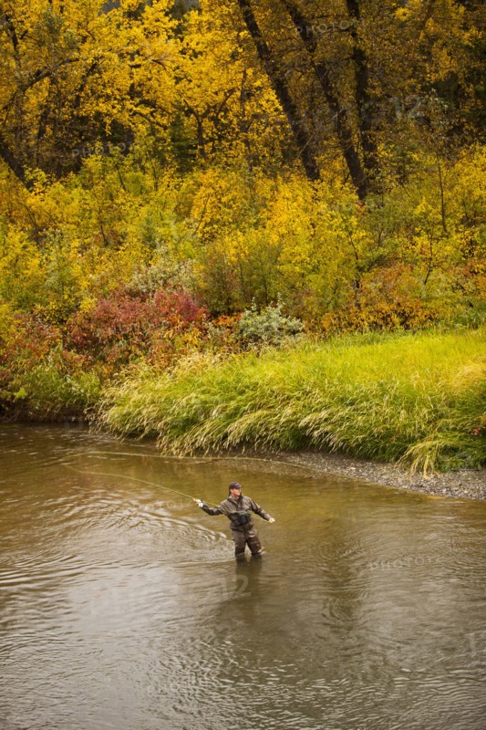 Caucasian man casting in river