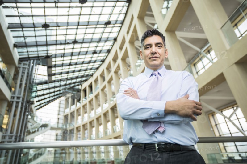Serious Mixed Race businessman posing in lobby