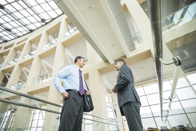 Smiling businessmen talking in lobby