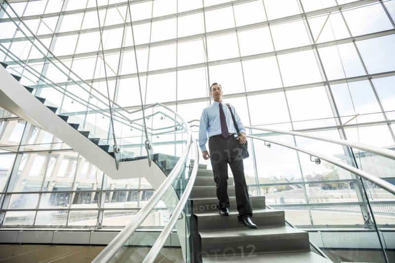 Mixed Race businessman descending staircase
