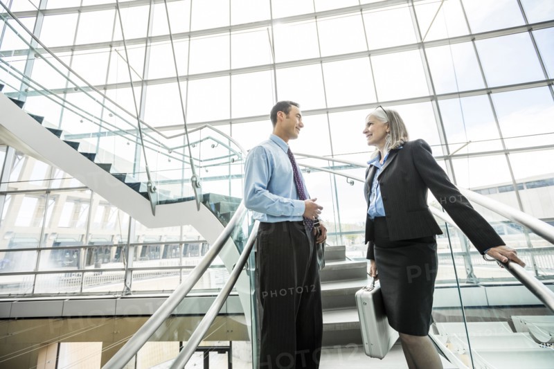 Business people standing on staircase and talking