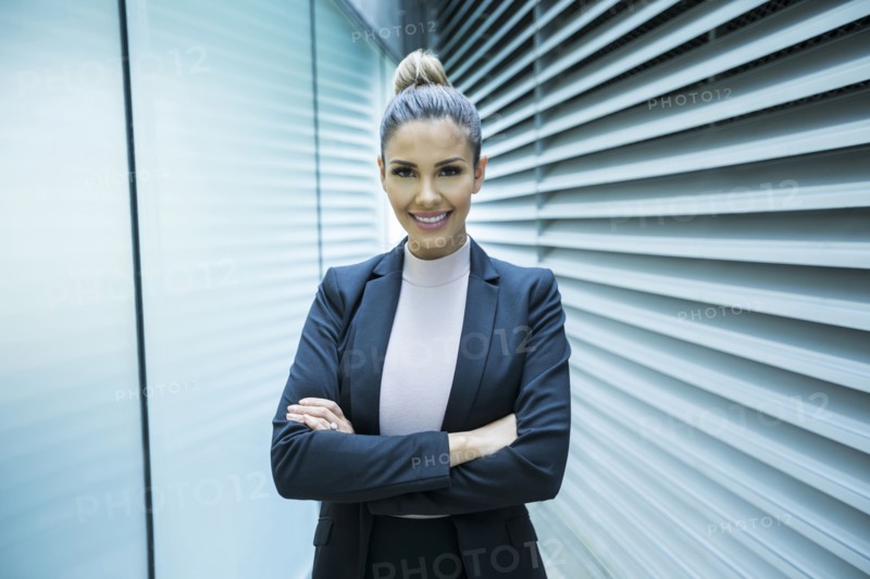 Portrait of smiling Mixed Race businesswoman in corridor