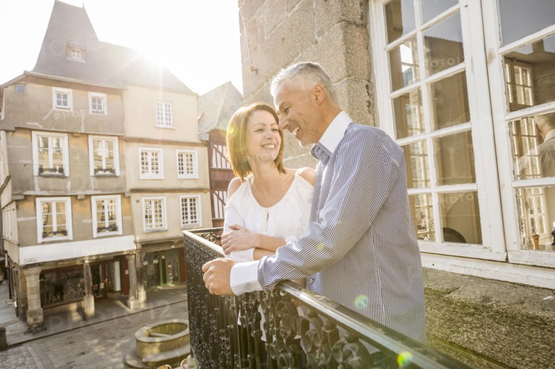Caucasian couple smiling on balcony in city