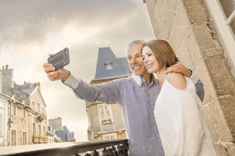 Caucasian couple posing for cell phone selfie