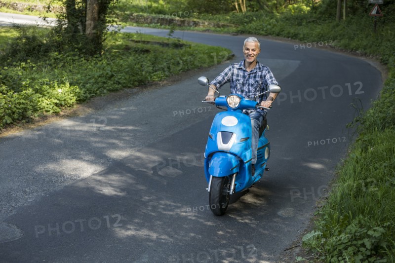 Caucasian man riding blue motor scooter