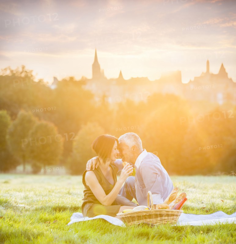 Caucasian couple enjoying picnic in grass