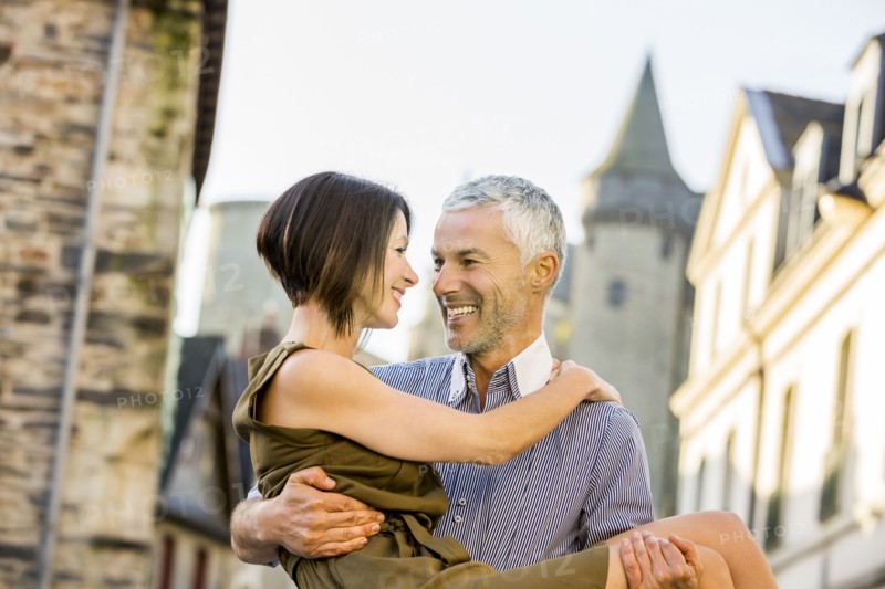 Caucasian man carrying a woman in city