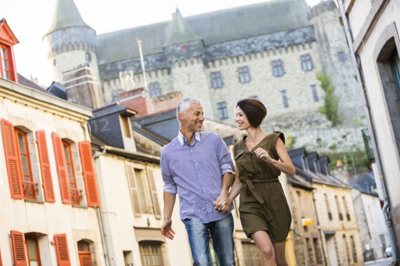 Caucasian couple holding hands walking in city