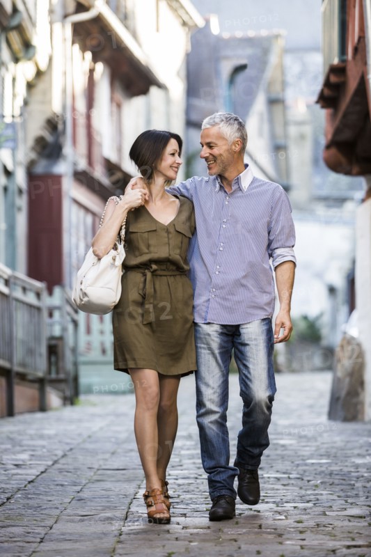 Caucasian couple hugging while walking in city