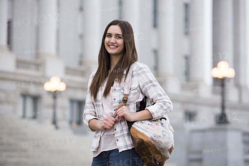 Smiling Caucasian woman carrying backpack at school