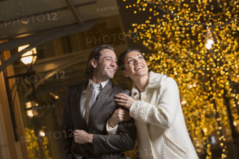 Caucasian couple walking in city at night