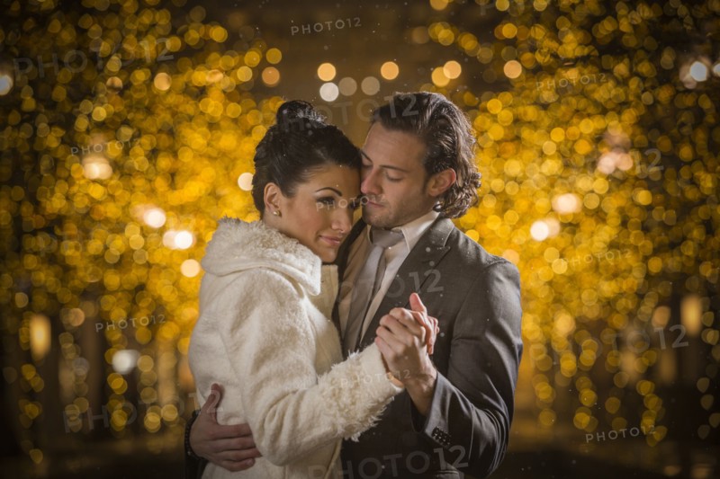 Caucasian couple dancing at night