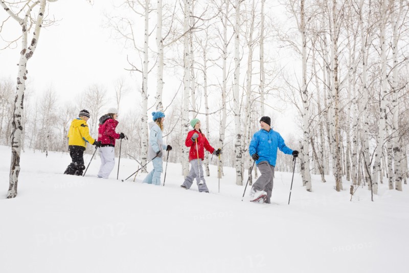 Caucasian family snowshoeing