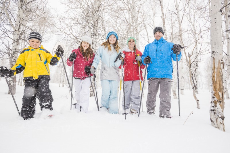 Portrait of smiling Caucasian family snowshoeing