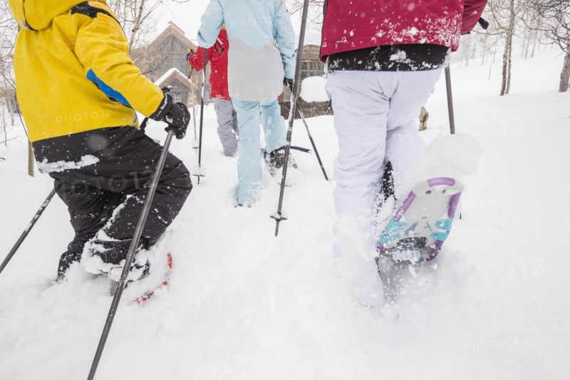 Rear view of Caucasian family snowshoeing