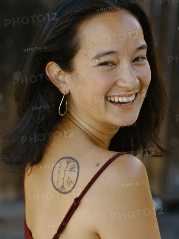 Smiling mixed race woman with tattoo