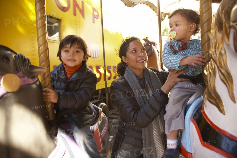 Mother and children enjoying carousel ride