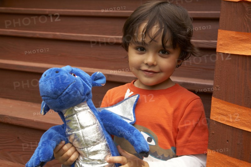 Mixed race boy holding stuffed dragon