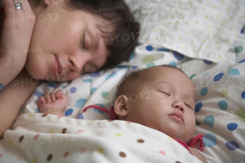 Mother sleeping with baby girl