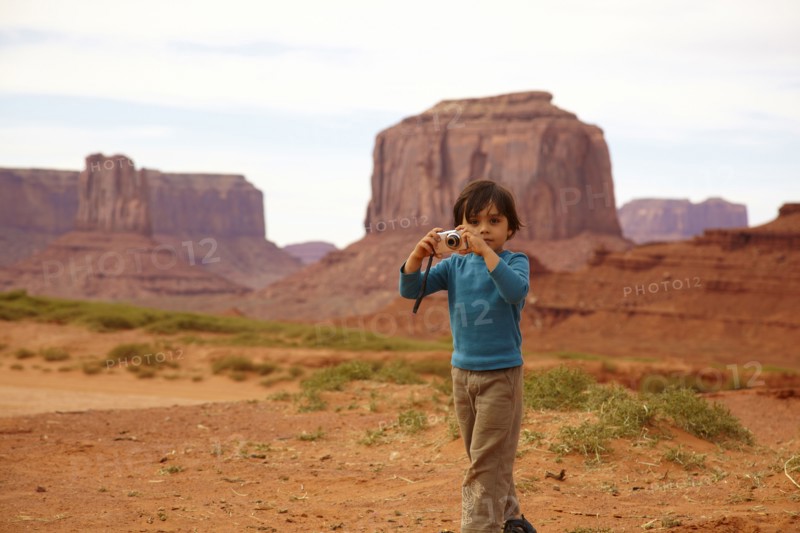 Mixed race boy taking pictures in Monument Valley