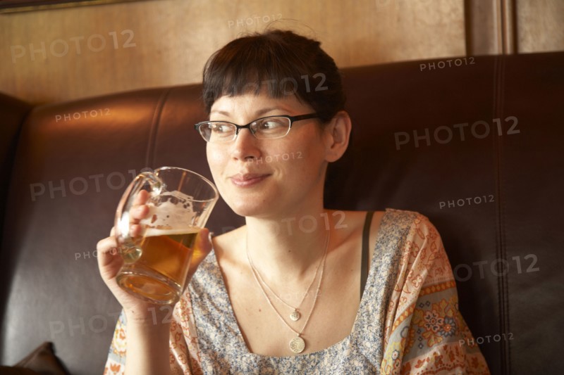 Mixed race woman drinking beer