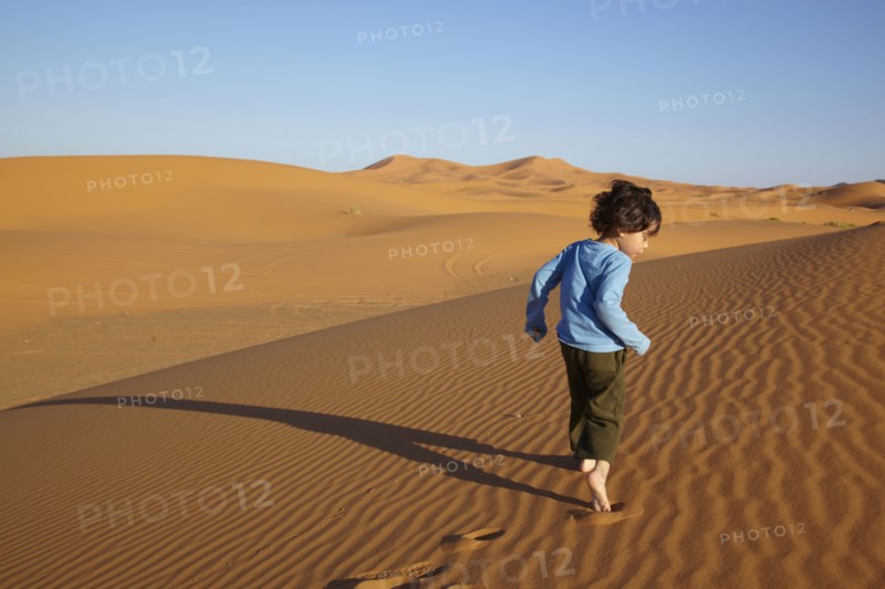 Mixed race boy running in desert