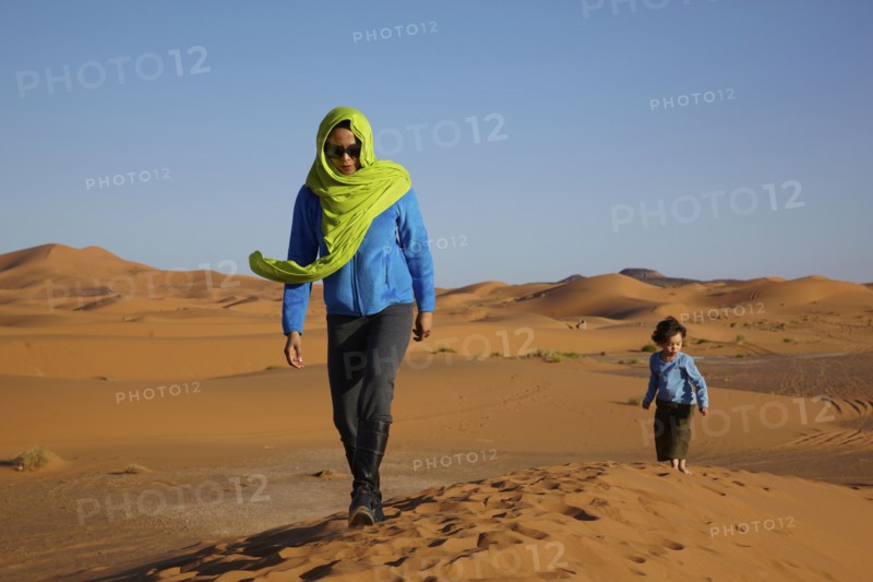 Mother and son walking in desert