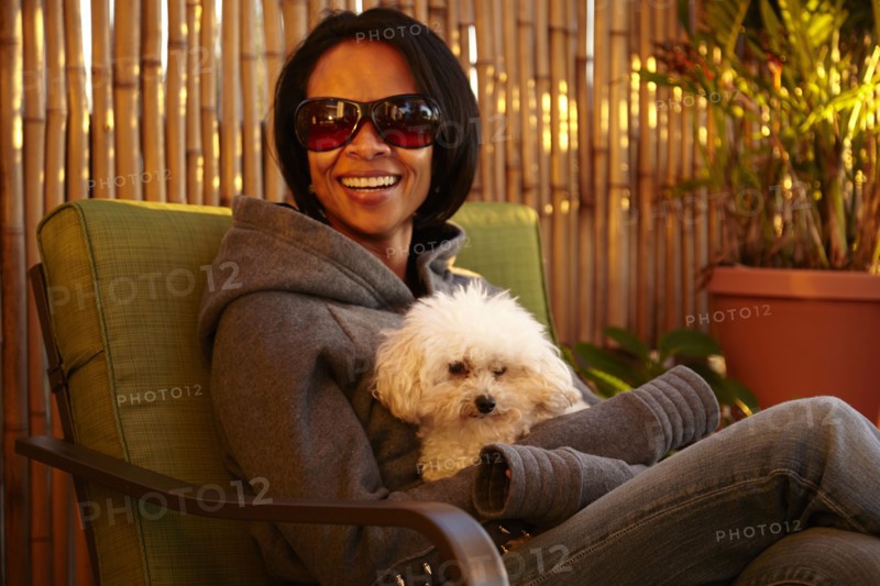 Mixed race woman sitting with dog outdoors