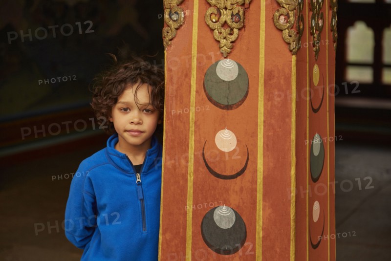 Mixed Race boy leaning on pillar