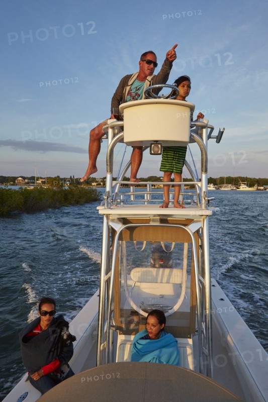 Man on boat tower pointing with son