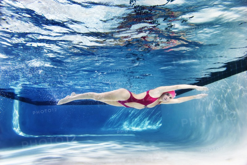 Caucasian woman swimming underwater