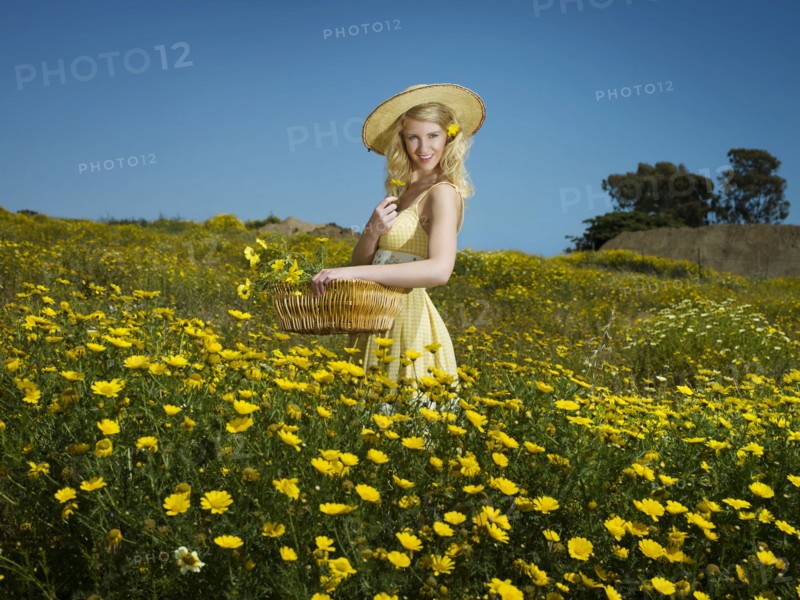 Caucasian woman picking wildflowers in field
