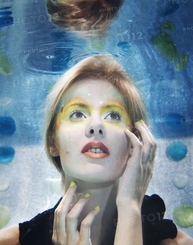 Caucasian woman with makeup on under water