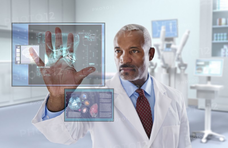 Black doctor looking at digital display in doctor's office