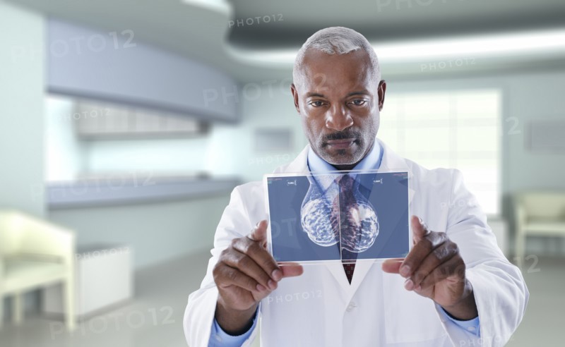 Black doctor using digital display in doctor's office