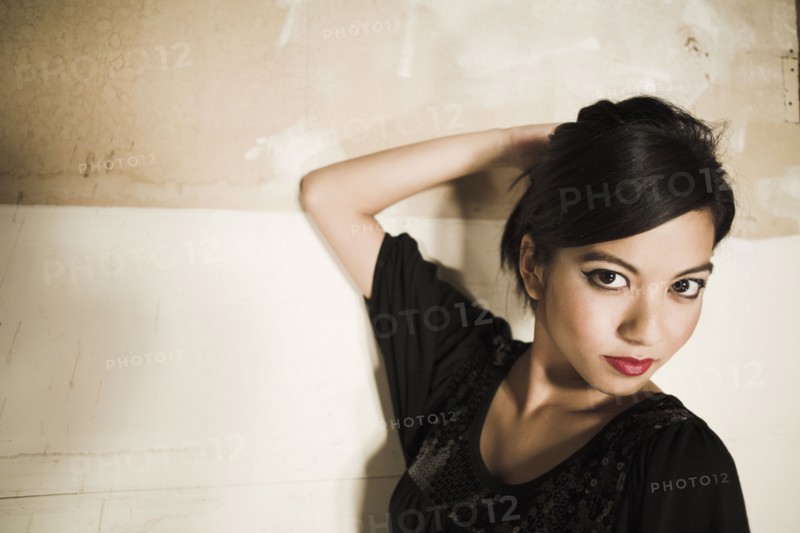 Asian woman with hand on head