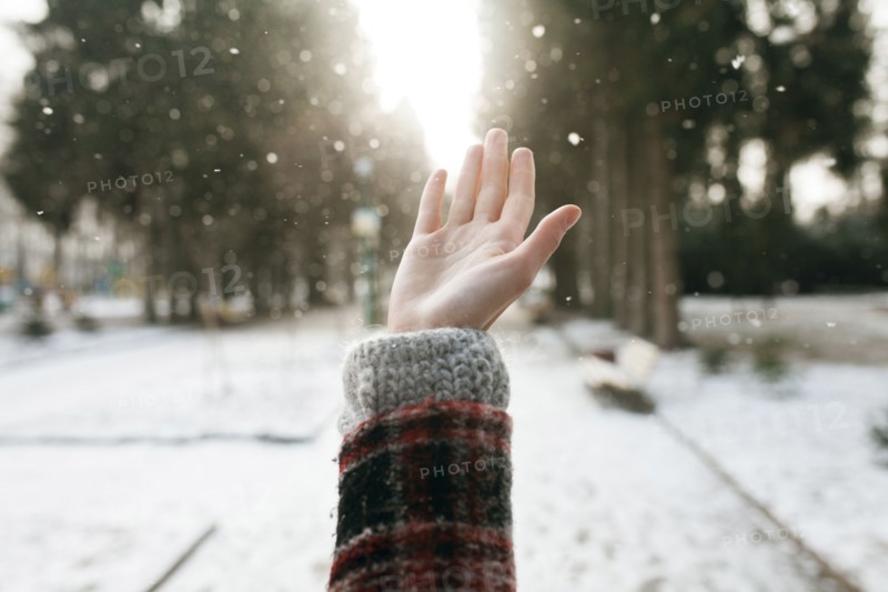 Hand of Caucasian woman catching falling snow