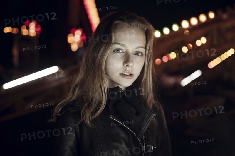 Caucasian teenage girl wearing leather jacket at night