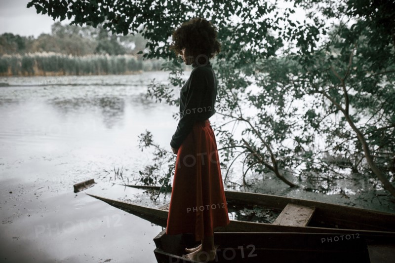 Caucasian woman standing in boat at river