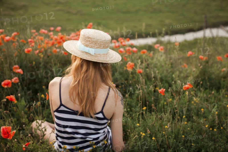 Caucasian woman sitting in wildflowers