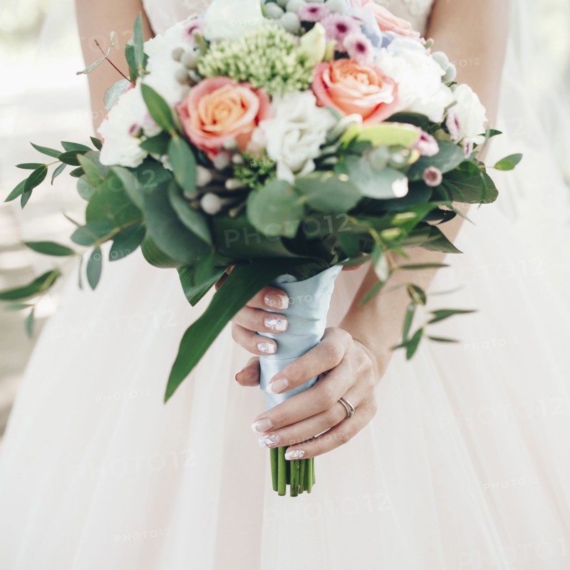 Caucasian bride holding bouquet of flowers