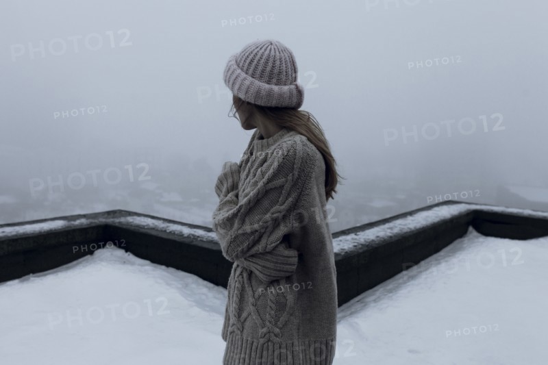 Caucasian woman standing on rooftop in winter