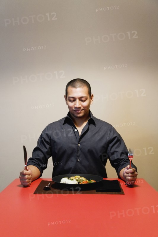 Asian man at table with full plate of food