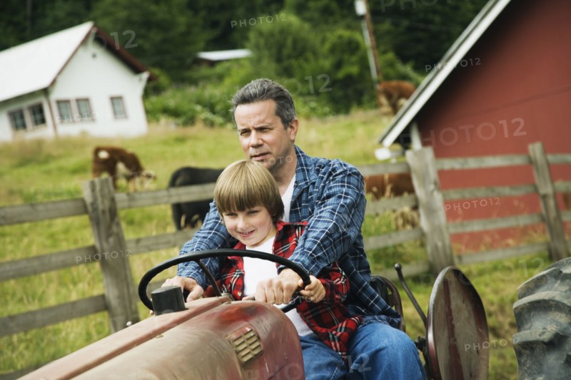 Father and son driving tractor