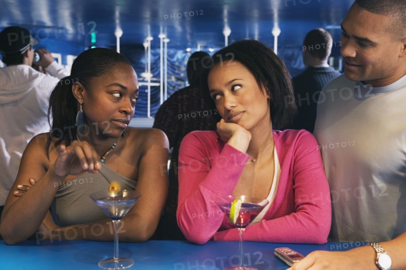 Two African women looking at each other at bar