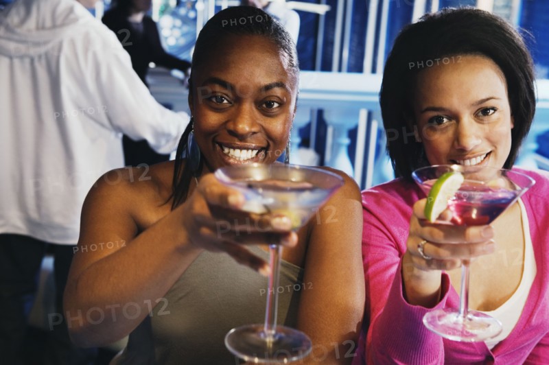 Two African women toasting with cocktails