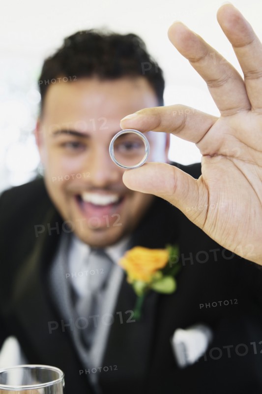 Hispanic groom showing ring
